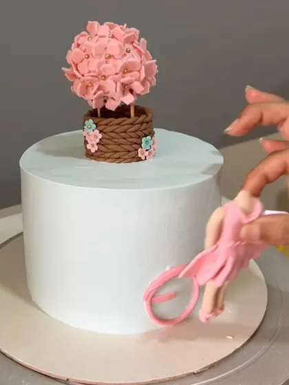 The process of adding the fondant girl and bicycle to the cake, showing how the scene comes to life.