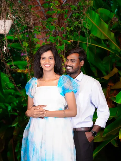 A happy couple's portrait against a lush green backdrop at night. The lighting is carefully set up to create a beautiful, soft glow.