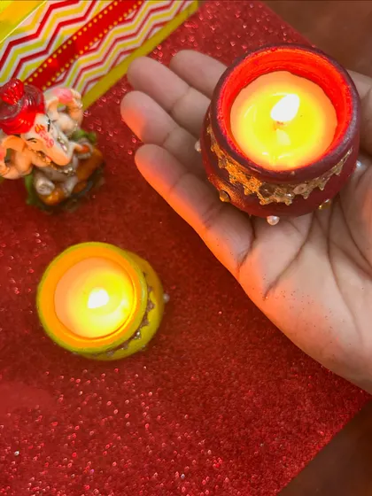 Holding one of the hand-painted terracotta matki candles. They are small enough to fit in your palm but bring so much festive cheer.