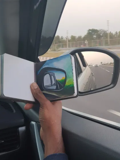 A creative exercise in perspective, where I painted the scene reflected in my car's side mirror. It's a painting within a photo, capturing the highway journey in a unique way.