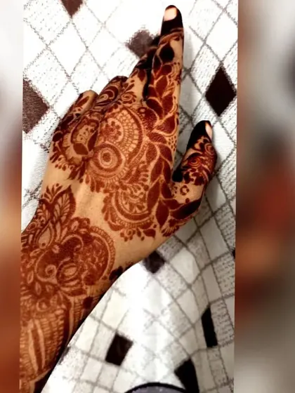 This image captures the lovely leafy and vine patterns of the henna stain on the back of the hand.