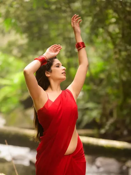 This shot captures a sense of movement and dance. The flowing red saree against the backdrop of the water is pure poetry.