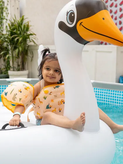 Another adorable guest enjoying a ride on the swan float, complete with cute arm floaties for extra safety.