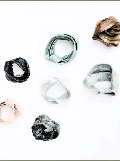 'Swirls of Life'. These small, ribbon-like ceramic sculptures can also be worn as unique, artistic brooches or pendants.