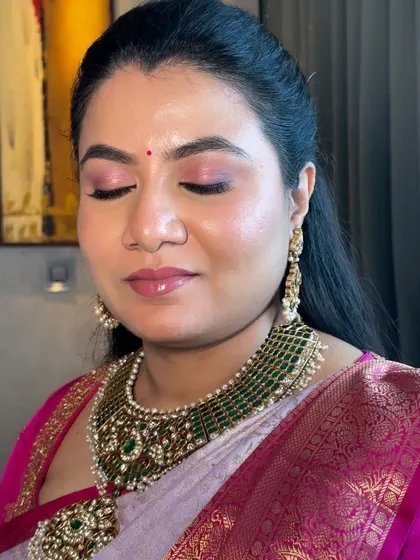 This is my signature skin-like finish. The makeup base is luminous and breathable, with a pop of pink on the eyes to complement her beautiful saree, perfect for any festive occasion.