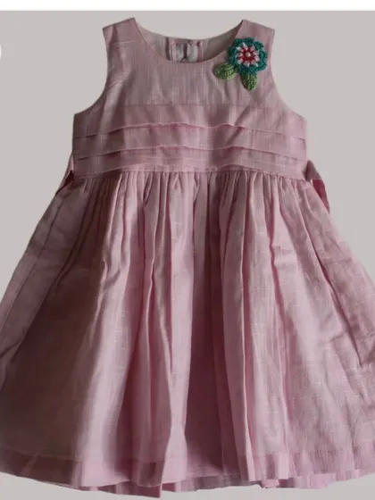 A single, multi-layered flower appliqué shown on a pink dress. This demonstrates how even one patch can serve as a beautiful focal point on a garment.