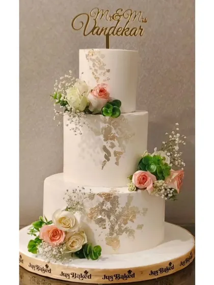 For a truly grand celebration, I created this three-tier eggless chocolate roasted hazelnut wedding cake. It combines rich flavor with the elegance of fresh flowers and delicate 24K gold leaf accents, making it a memorable centerpiece.