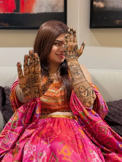 A playful pose from the bride, highlighting the design on one palm and the back of the other hand. This shows the versatility and beauty of the complete bridal package.