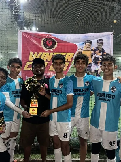 The victorious Under-15 team with their coach and the winner's trophy after a successful campaign at the Winter Cup.