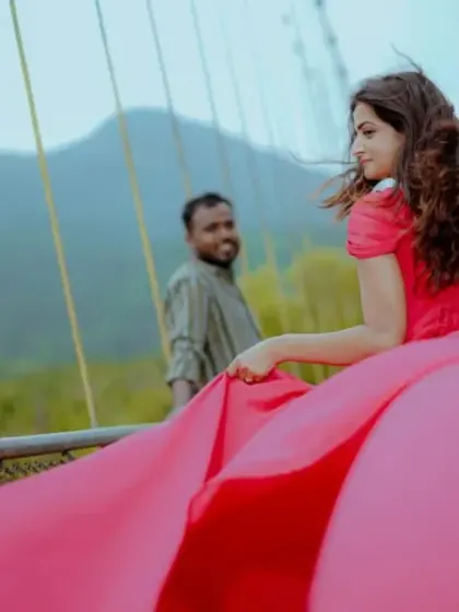 A candid shot on a bridge, where the long trail of the pink gown flows behind the client, adding a sense of movement and romance.