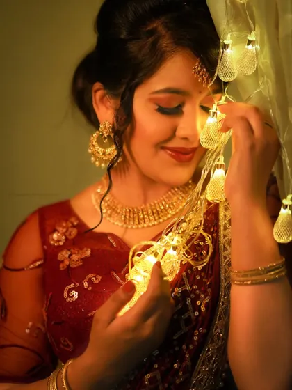 A close-up of the model with the fairy lights, creating a beautiful bokeh effect and a warm, celebratory mood.