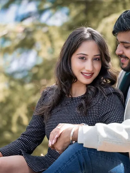 A sweet, sunlit portrait of the couple sitting together. The natural light highlights their happy expressions and easy chemistry.
