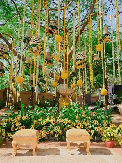 For this haldi, we used a beautiful existing tree as the main backdrop, enhancing it with hanging floral baskets and marigold strings.