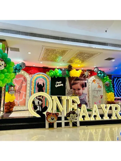 Welcome to the jungle! This is one of my favorite setups, showing a complete stage decoration for a jungle safari theme. I use large marquee letters, custom backdrops, and plenty of animal props to create an immersive world for your child's big day.