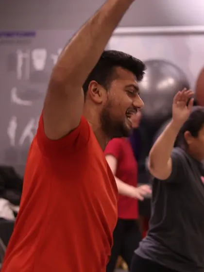 A candid shot of a member letting loose and feeling the Bhangra groove. This image captures the pure expression of joy that comes from dance fitness.