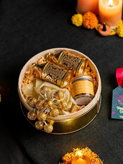 A chic and modern gift set in a round box, featuring gold-plated glasses and fairy lights. This is a perfect example of a stylish and contemporary gift.