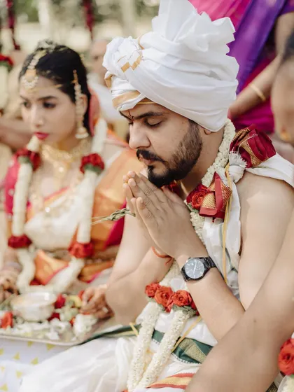 A quiet moment of prayer for the groom during the wedding rituals. This shot captures his focus and reverence, an important part of the spiritual journey of the wedding day.