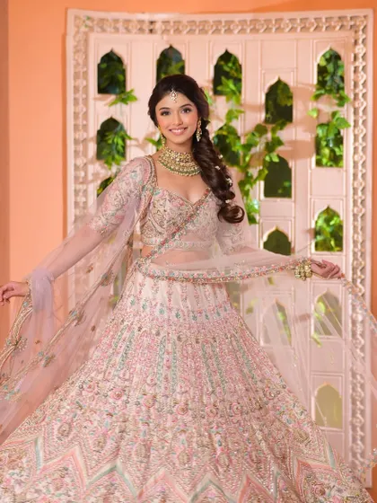 The full-length view of this pastel lehenga look, showing a happy and radiant bride, perfectly styled from head to toe.