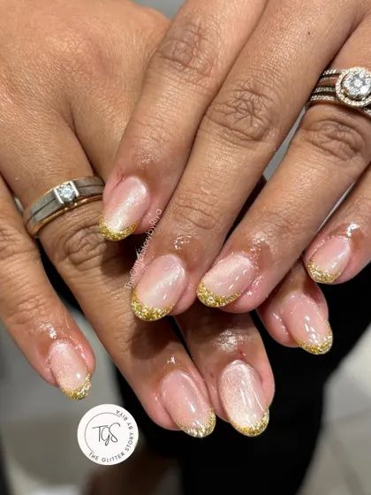 A sparkling gold glitter French tip manicure. This is a perfect look for festive occasions or for anyone who loves a bit of glamour.