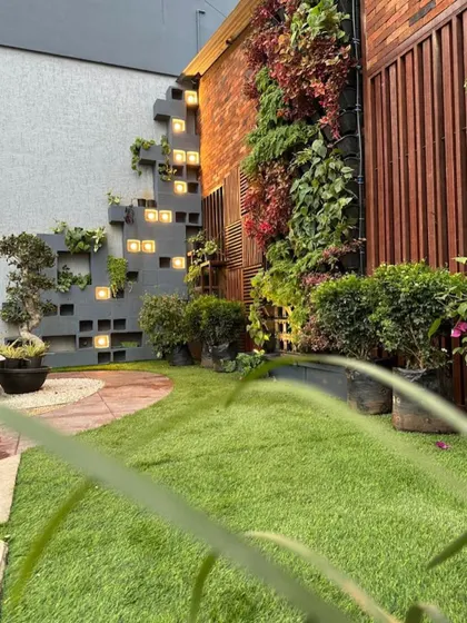 This image from my experience center showcases a creative wall design. It combines a vertical garden with an integrated shelving structure made of concrete blocks, which are backlit for a dramatic effect at night.