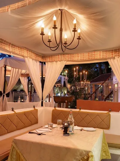 A view from inside one of our larger cabanas, perfect for small groups. The chandelier and comfortable seating create a luxurious yet cozy private dining space.