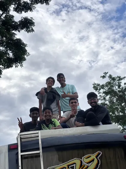 A group of young men from a college trek posing on top of the bus. The fun and bonding start from the journey itself.