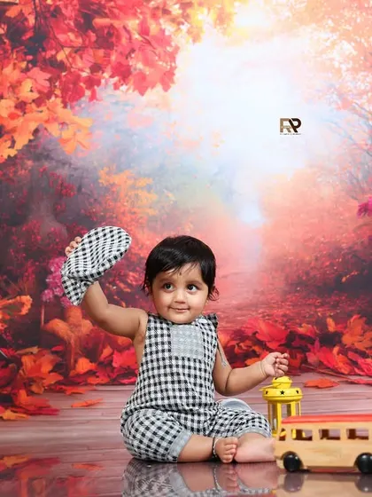 A baby boy in a checkered outfit tips his hat in this playful shot from the autumn forest session. The reflections on the floor add a beautiful, professional touch.