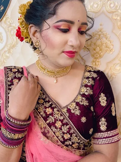 A client wearing a velvet blouse, with makeup featuring a pop of pink on the eyes.
