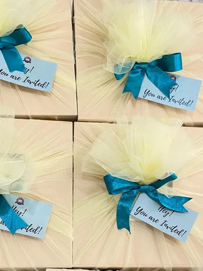 Beautifully wrapped corporate event invitations. The simple yet elegant packaging with tulle and a ribbon adds a personal touch to a formal invitation.