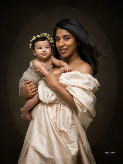 A mother and her baby captured in a beautiful fine art style. The soft, directional light creates a classic, painting-like quality.