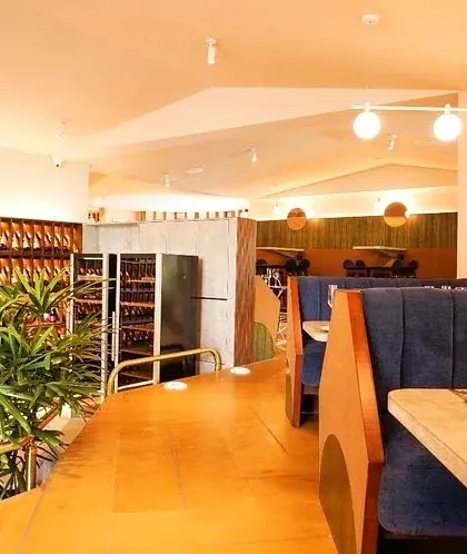 The warm lighting and rich blue upholstery at Haute create a cozy and luxurious environment for dining.