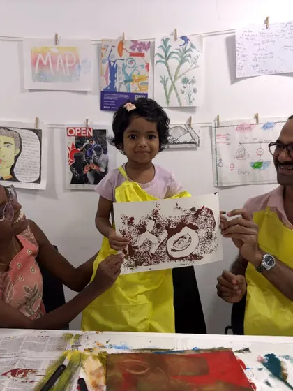 A proud family shows off the print they created together at the Colourful Connects workshop. These collaborative art projects are a wonderful way to build lasting memories.