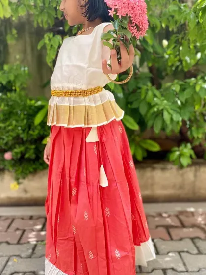 The Nila set is all about elegance and comfort. The peplum top with a Kasavu border pairs beautifully with the peach skirt, and the entire outfit is made of soft cotton to keep your little girl happy.