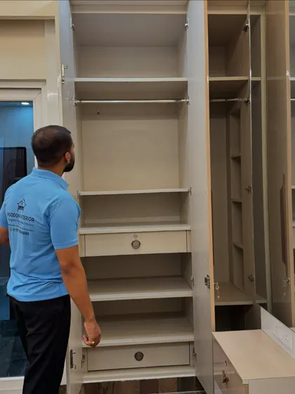 A view inside the wardrobe, showing the organized layout with hanging rods, shelves, and internal drawers for different types of clothing.