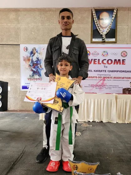 A student stands with his coach after winning at a state-level championship. Our coaches provide personal guidance and support at every competition.