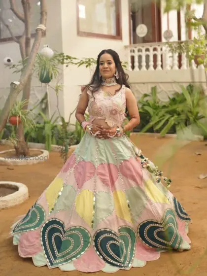 A client looking lovely in the heart-patterned lehenga at an outdoor event.