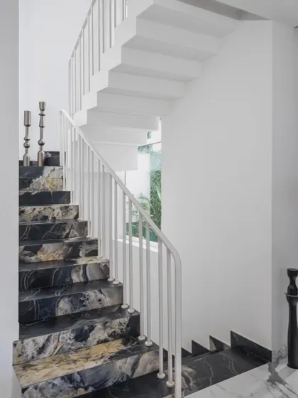 We love a good staircase. This one is flanked by large windows overlooking the courtyard, and we chose a dark, dramatic marble for the treads to create a beautiful contrast with the white walls.