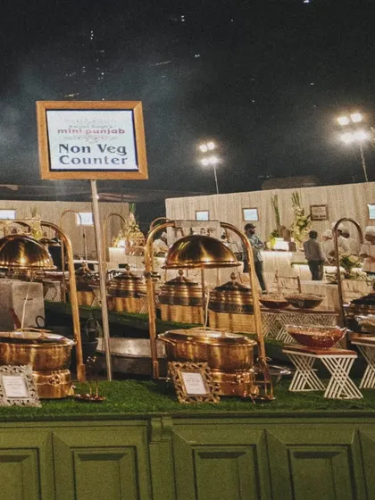 A view of our non-vegetarian counter, part of a larger, beautifully organized buffet line at an outdoor event.