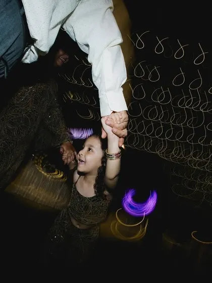 A father and daughter share a dance. The slow shutter speed creates a beautiful motion blur, emphasizing the movement and the special bond between them.