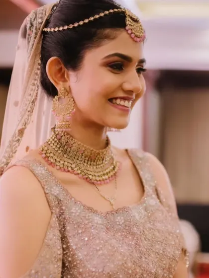 The finished look is pure bridal bliss. Her smile shows how confident and beautiful she feels with her flawless, glowing makeup.