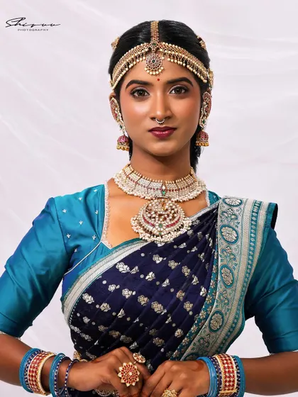 A close-up of the makeup and jewelry for a concept shoot. The look features a bold lip, defined eyes, and stunning traditional headwear, creating a powerful and artistic statement.