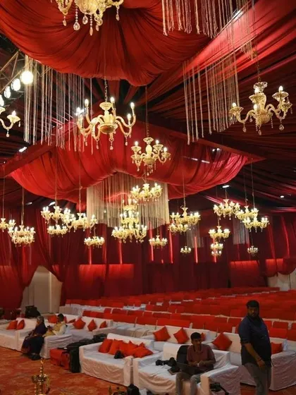 The convention center transformed for another event, with red drapery and crystal chandeliers. This demonstrates the versatility of the space, which can be a humble backdrop for any kind of celebration.