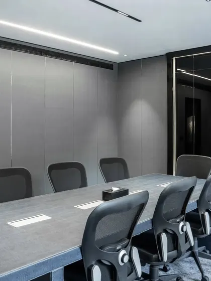 For this chairman's conference room, I focused on creating a space with a strong, masculine aesthetic. I used textured leather panels on the walls and a custom-made conference table with a croc-style leather finish, complemented by a full-wall black lacquer glass writing board for a modern, sophisticated look.