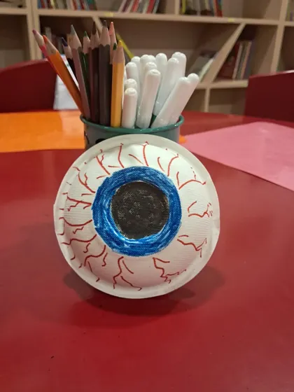 A close-up of a paper plate eyeball craft. This activity helps children learn the different parts of the eye in a creative, hands-on manner.