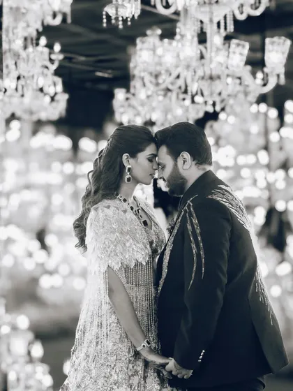 A romantic black and white portrait of Manisha and Vansh. The contrasting textures of their outfits and the bokeh of the chandeliers create a truly magical photo.