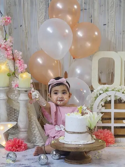 A sweet moment of this little one enjoying her cake, surrounded by soft pinks, creams, and glowing stars.