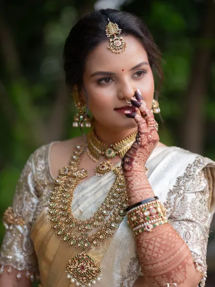 A captivating portrait of a South Indian bride. The makeup is elegant and refined, with a focus on her expressive eyes and flawless skin.