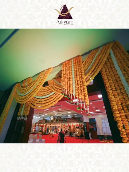 A grand entrance to a convention hall, draped with long garlands of marigolds. This simple but effective decor creates a massive visual impact and a festive welcome.