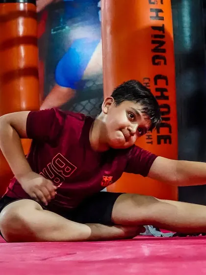 A young warrior works on his flexibility. We teach kids that discipline and hard work are fun and rewarding.