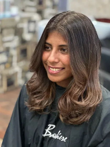 Fearless transformation. This client's new look features a soft, warm brown balayage that adds dimension and shine, finished with a happy smile.